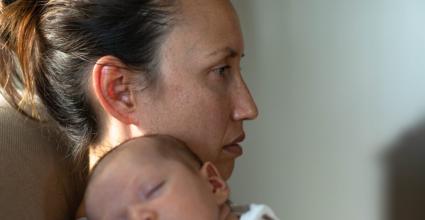 maman posé sur le canapé et bébé aux bras