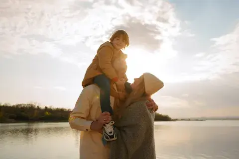 famille près d'un lac avec soleil derrière