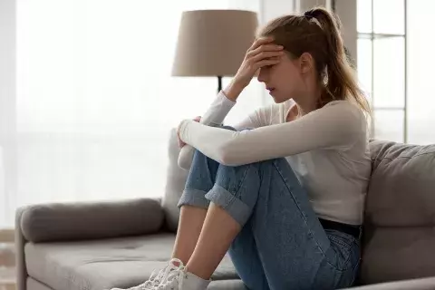 femme assise qui souffre de troubles mentaux