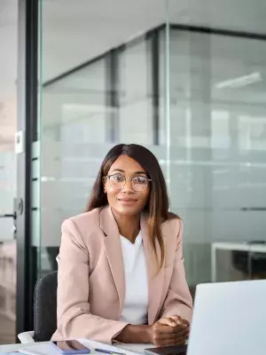 femme noire à lunettes devant son bureau