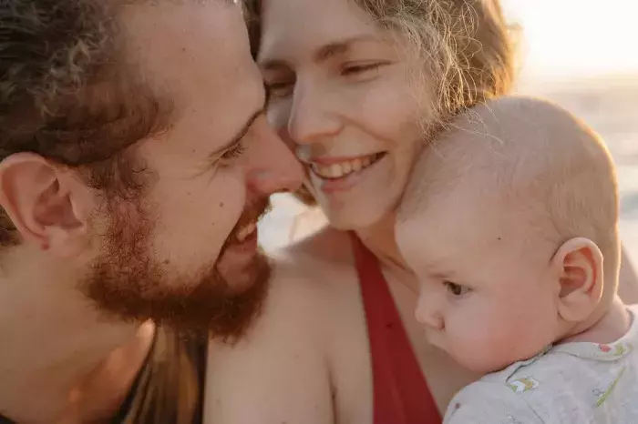 famille heureuse avec bébé sur la plage